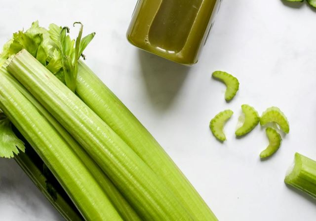 Ogonki liściowe selera naciowego i&nbsp;butelka z&nbsp;zielonym sokiem naciowym